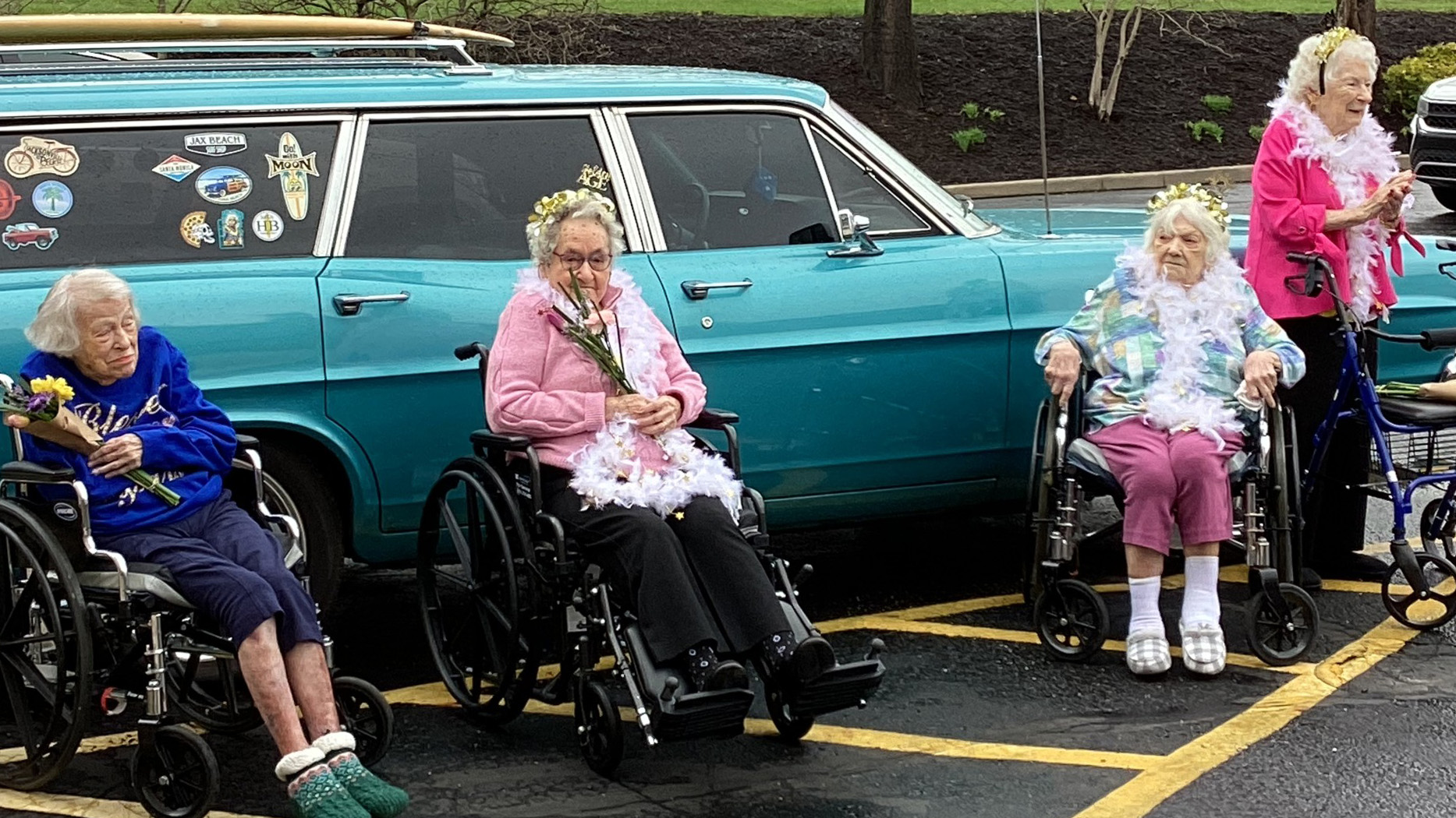 Seniors in wheelchairs enjoying classic car display